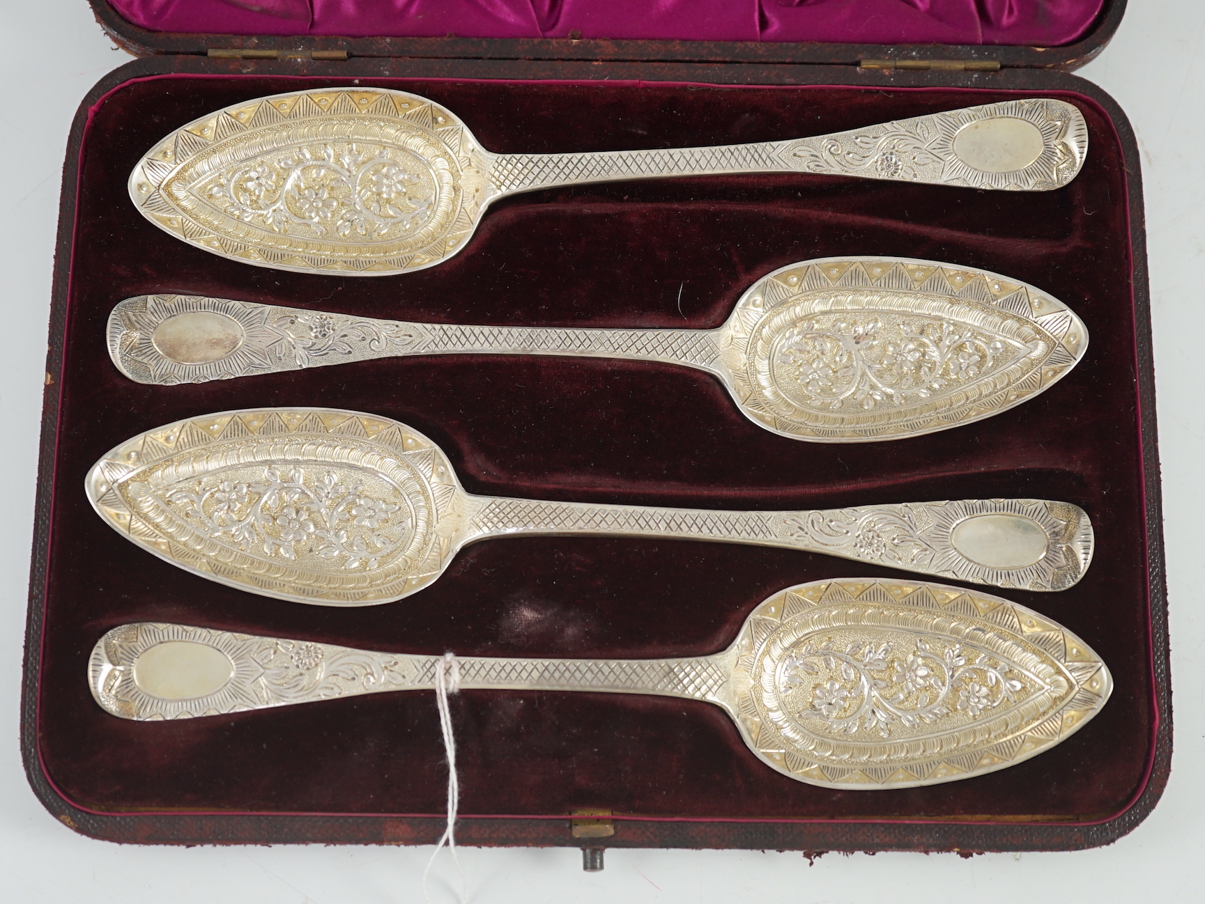 A cased set of four late George III embossed and engraved parcel gilt silver Hanovarian pattern serving spoons, William Chawner II?